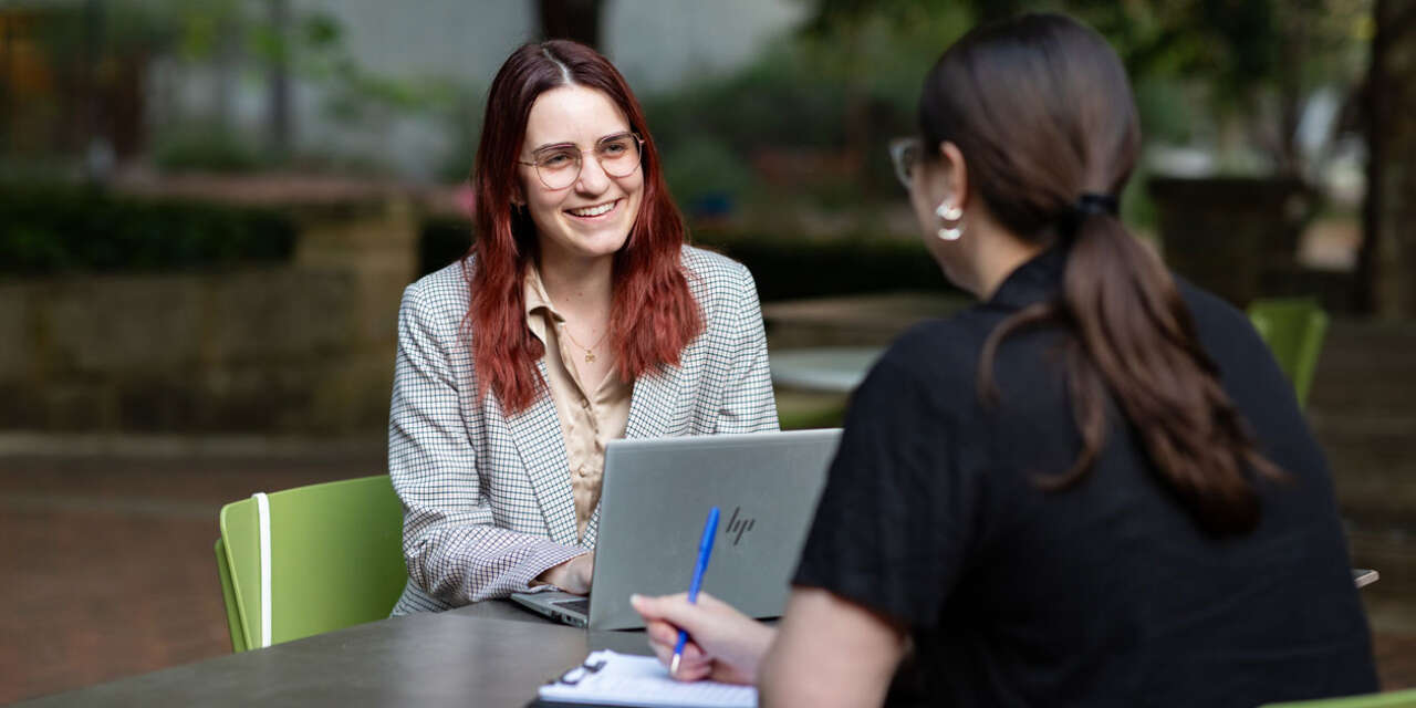 Female university students practise interviewing.