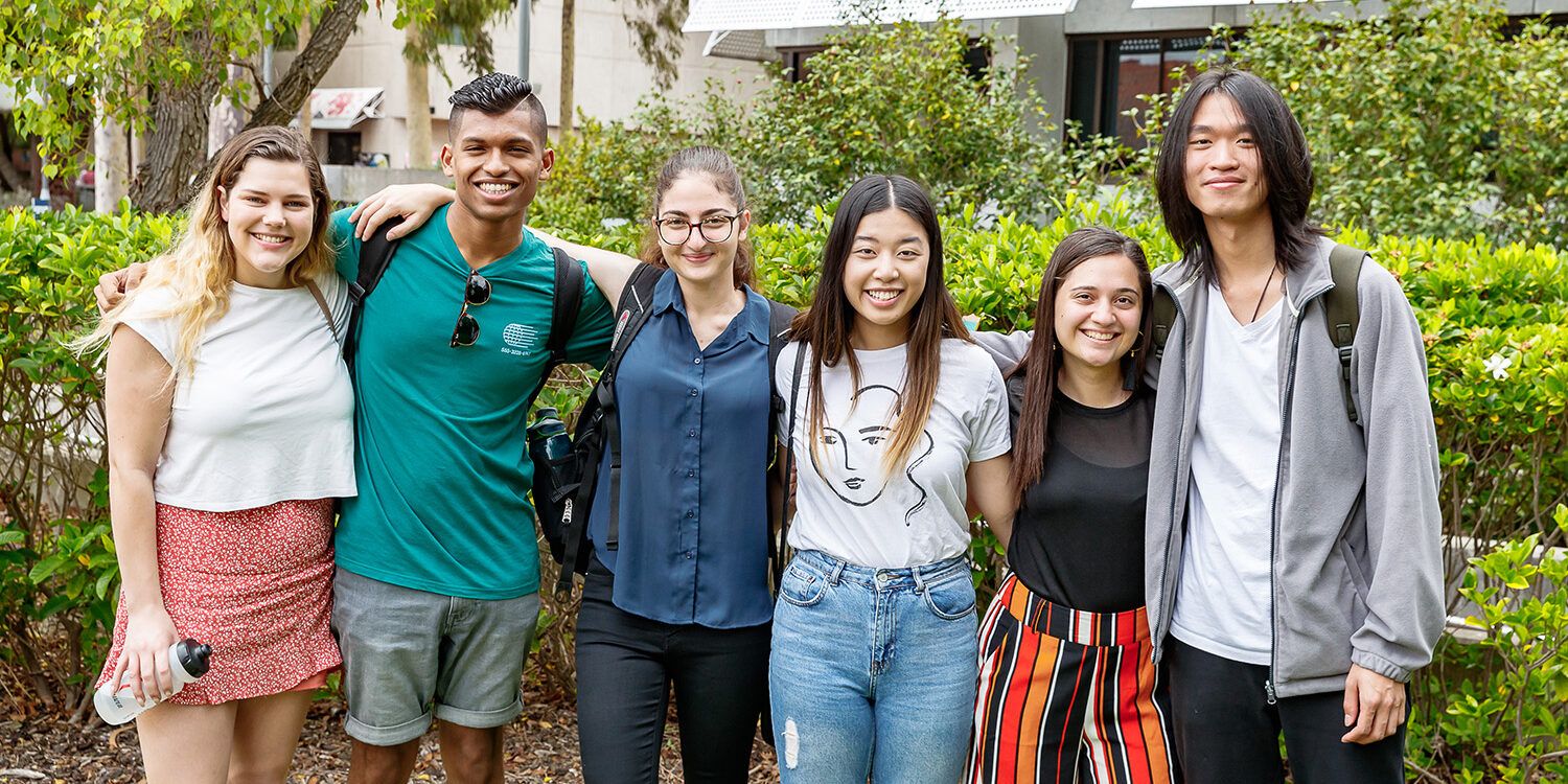 Group of students standing together with arms around each other