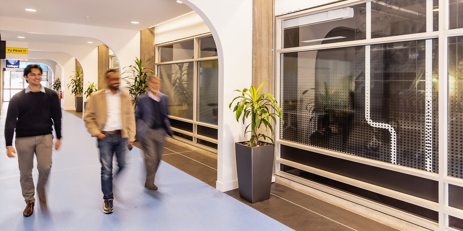 Three people walking down a corridor blurred from movement