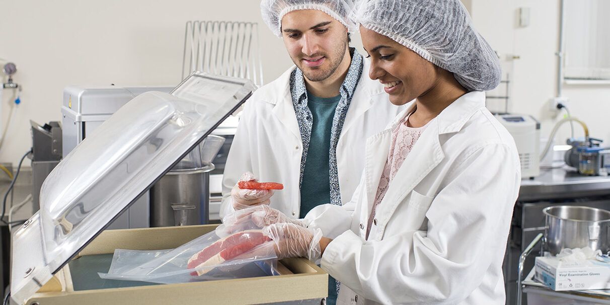 2 students inspecting frozen meat