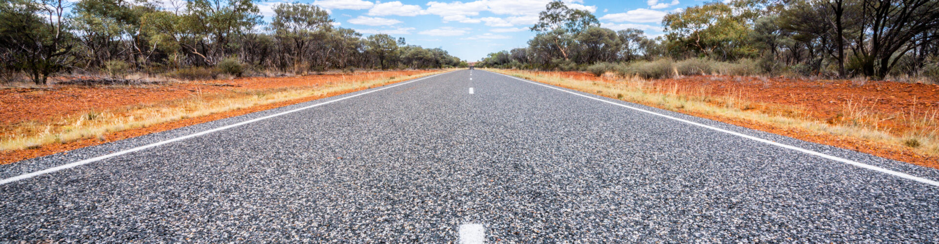 Straight road with white lines in middle of outback red centre NT Australia.